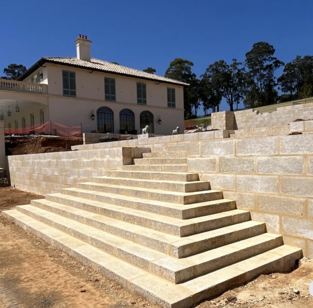 Grand limestone block staircase leading up to a residential estate